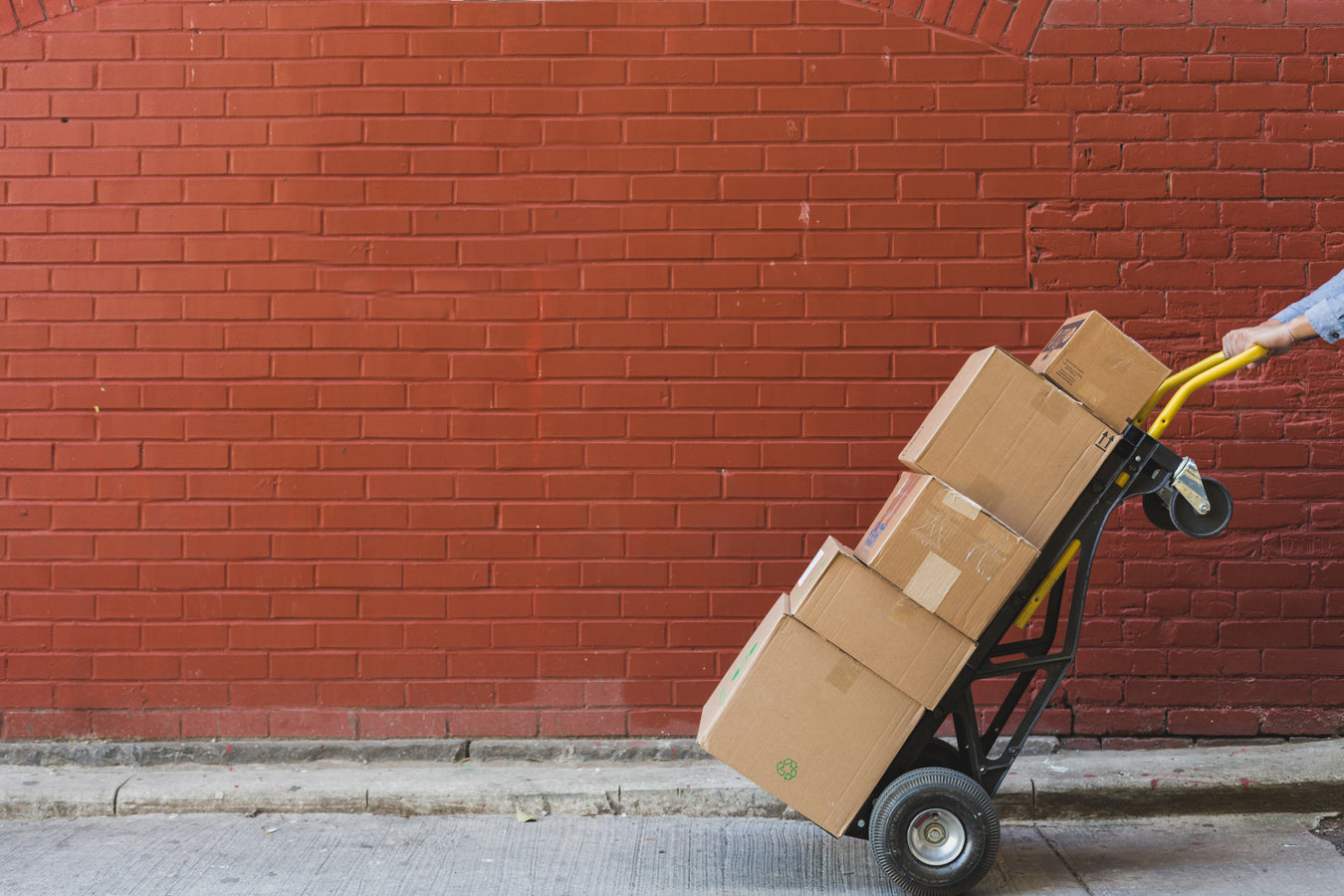 shipping options: 5 cartons on a two wheel dolly in front of a red brick wall